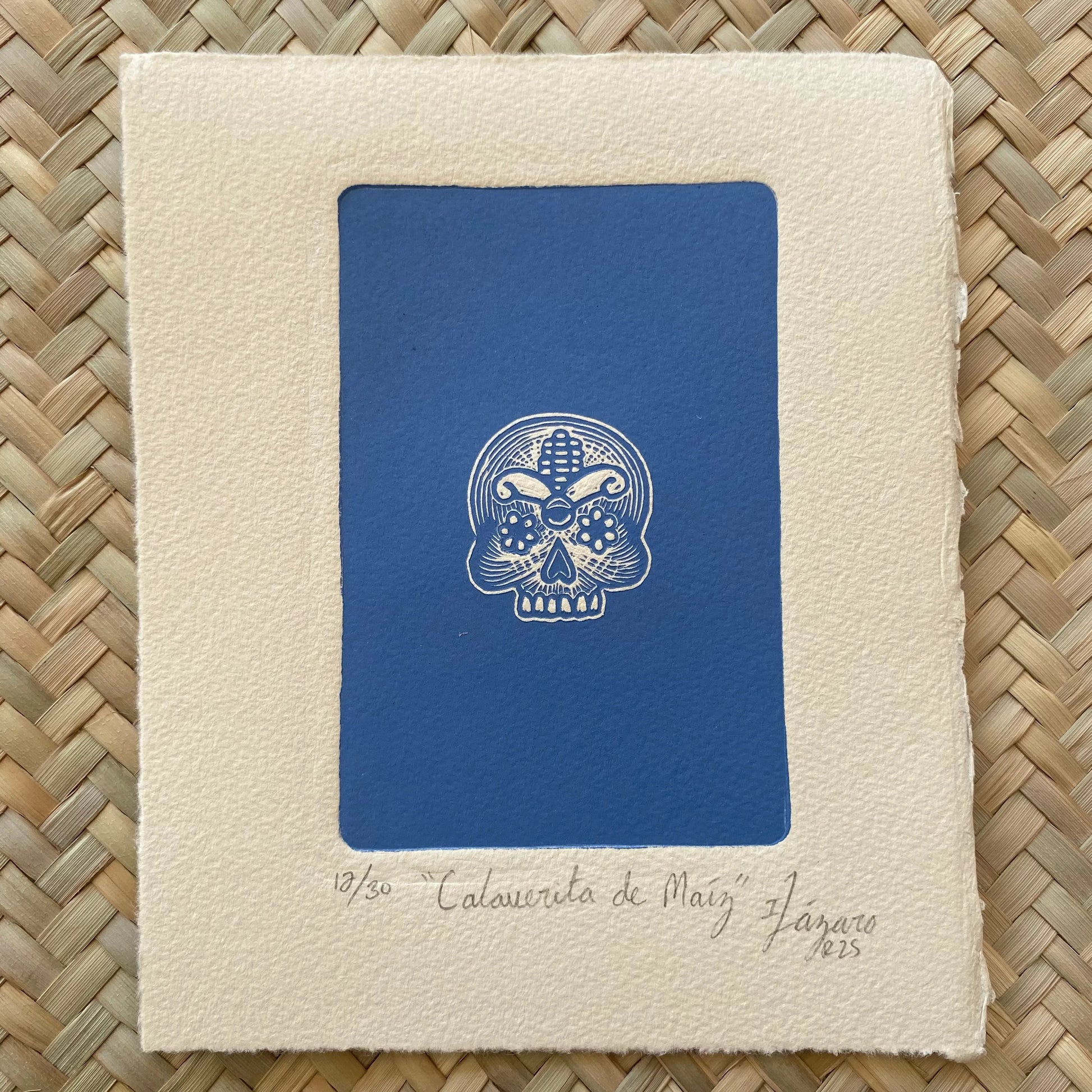 Linograbado "Calaverita de Maíz" de Iliana Lázaro. Tema de cultura mexicana en azul y blanco.